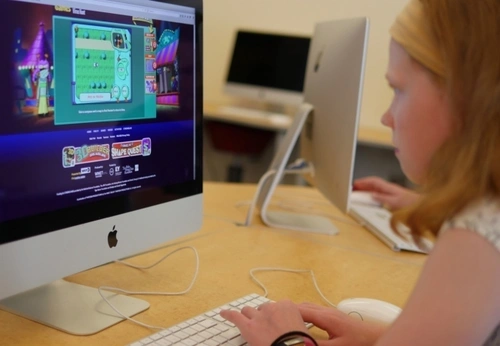 A child sits at a computer working on an online learning exercise.