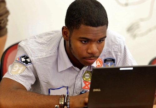 A student works at a laptop computer.