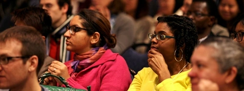 Two women in bright outfits sitting in the Ethnography Forum audience.