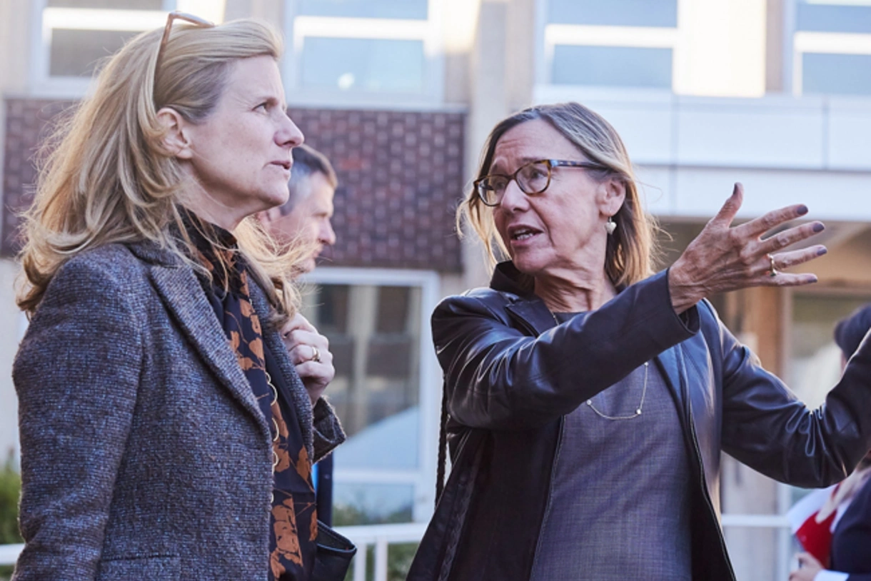 Dean Pam Grossman and President Liz Magill stand outside the Penn GSE building expansion project on a tour as the dean gestures at the construction.