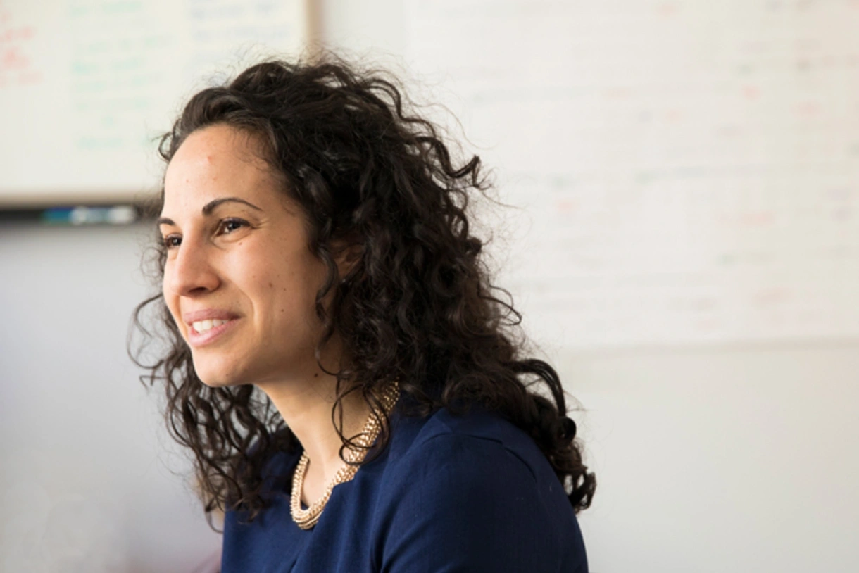 A headshot of Sharon Wolf smiling in profile in her classroom.