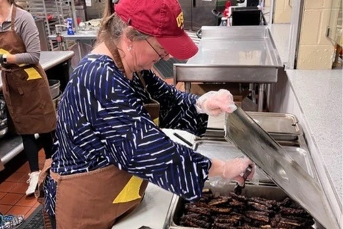 Julee Gard serving a meal at a local soup kitchen