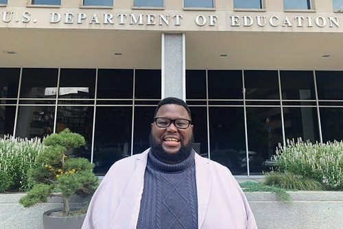 Mark Ziegler-Thayer stands in front of the Lyndon Baines Johnson Department of Education Building