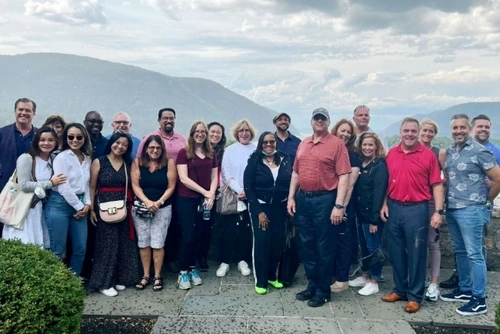 Penn GSE students and alumni posed in front of a mountain view for group photo