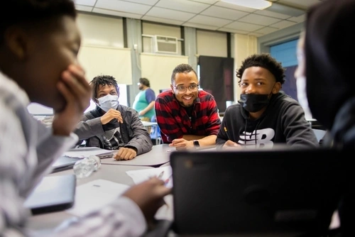 Tamir Harper smiles with his students at Henry C. Lea School