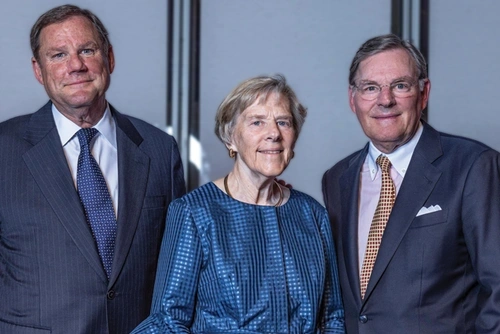 The McGraw siblings , Robert, Suzanne, and Harold III , stand together smiling.