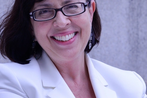 Sarita E. Brown posed against a wall smiling