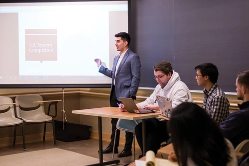 Higher Ed student giving a presentation with a PowerPoint to their class