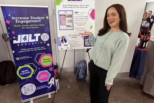 Jade Peterson poses with Jolt Education's table at the Penn Startup Showcase 2025.