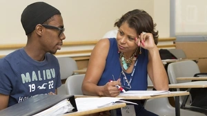 A teacher tutors a student. 
