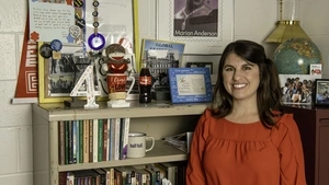 Nimet Eren poses by a bookshelf of her artifacts in her office