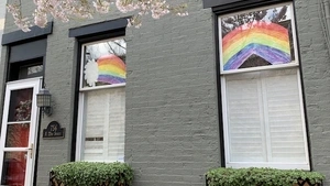 A house with drawings of rainbows in the window. 