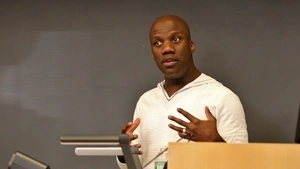 Shaun Harper standing in front of blackboard