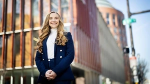 Lorea Peterson Rodondo stands in front of the Penn GSE building and Wharton's Huntsman Hall